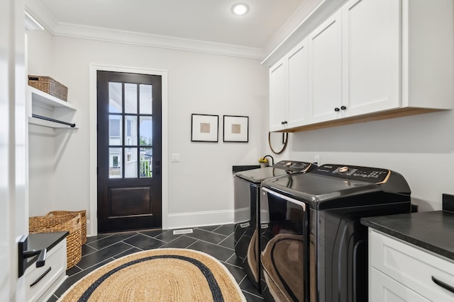 clothes washing area with cabinets, ornamental molding, washer and dryer, and dark tile patterned flooring