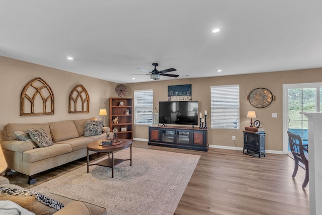 living room featuring ceiling fan and light hardwood / wood-style flooring