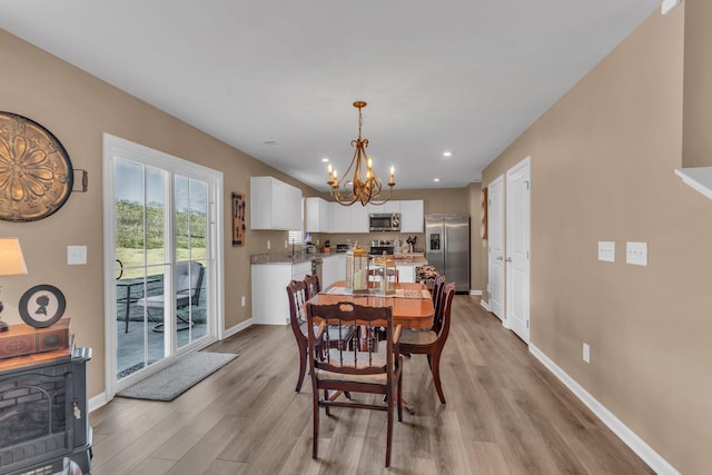 dining room with an inviting chandelier and light wood-type flooring