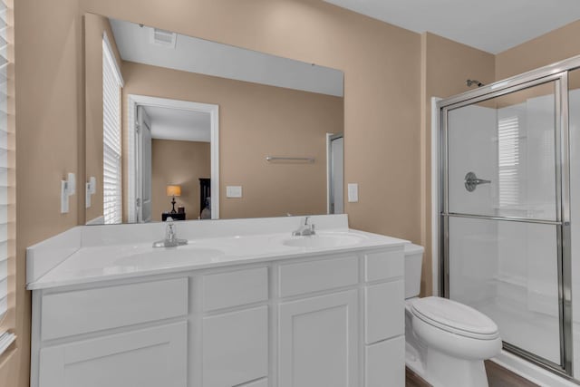 bathroom featuring wood-type flooring, toilet, an enclosed shower, and vanity