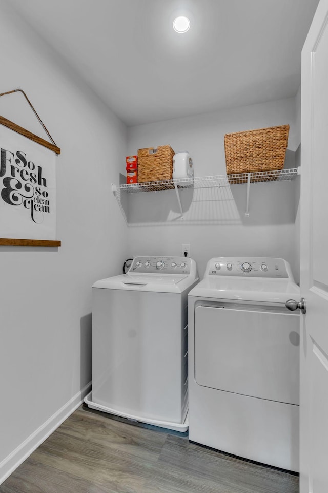 clothes washing area with dark hardwood / wood-style floors and washer and clothes dryer