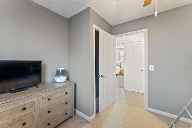 bedroom with light carpet, a textured ceiling, and ceiling fan