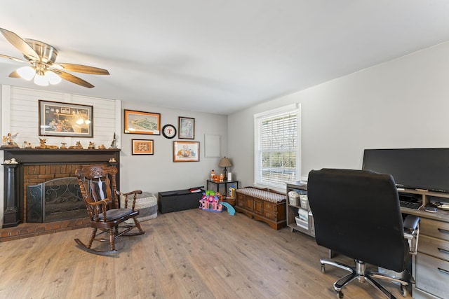 office featuring ceiling fan, wood-type flooring, and a fireplace