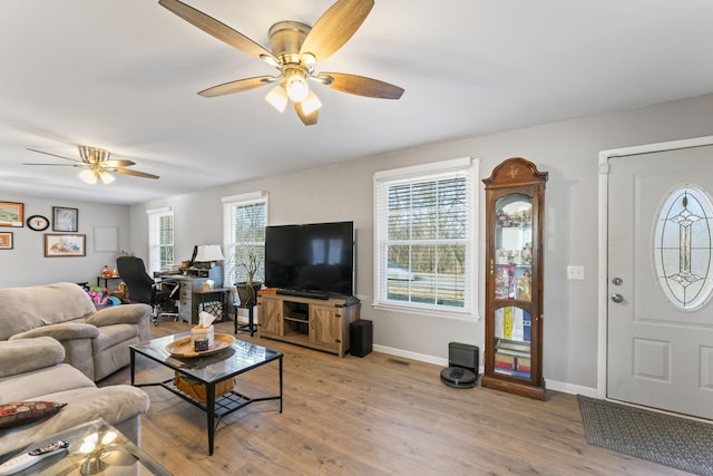 living room featuring a wealth of natural light, ceiling fan, and light hardwood / wood-style flooring