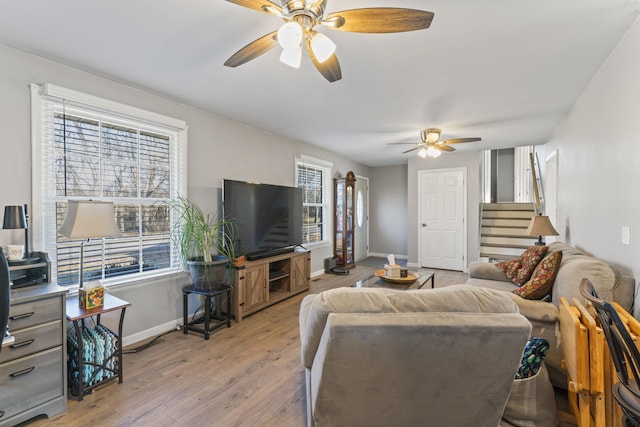 living room featuring ceiling fan, plenty of natural light, and light wood-type flooring