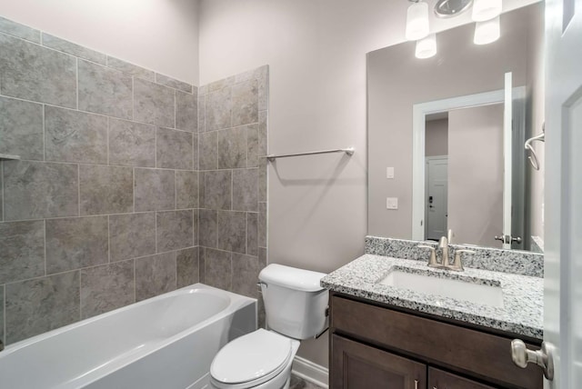 full bathroom featuring vanity, tiled shower / bath, and toilet