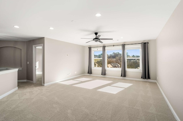 unfurnished room with light colored carpet and ceiling fan