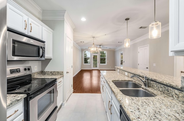 kitchen with stainless steel appliances, white cabinetry, sink, and pendant lighting