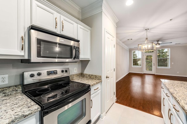 kitchen featuring crown molding, appliances with stainless steel finishes, hanging light fixtures, light stone countertops, and white cabinets