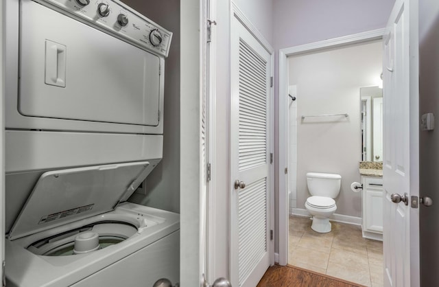 washroom featuring stacked washer and dryer and tile patterned floors