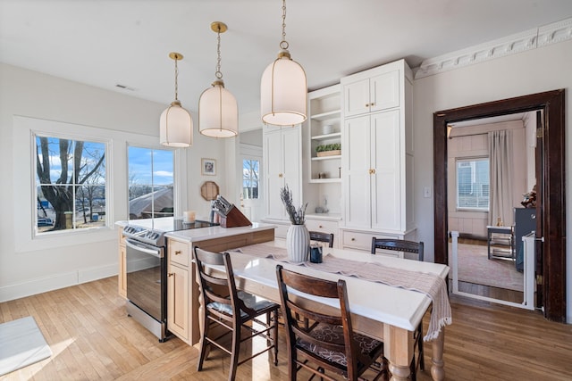 kitchen featuring pendant lighting, white cabinetry, a wealth of natural light, and stainless steel electric range oven