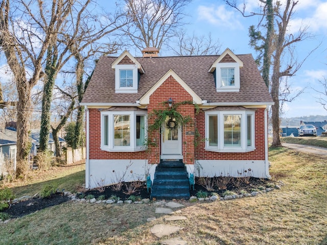 cape cod home featuring a front yard