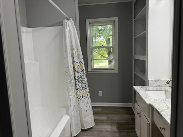 bathroom with wood-type flooring, shower / bathtub combination with curtain, and vanity