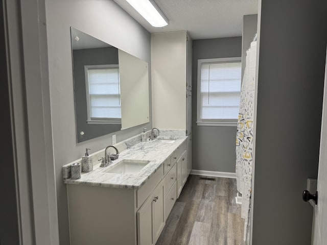 bathroom with hardwood / wood-style flooring, vanity, and a textured ceiling