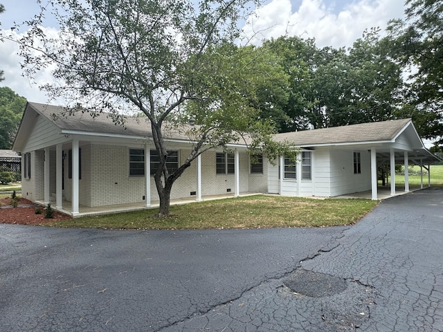 ranch-style house featuring a carport and a front lawn