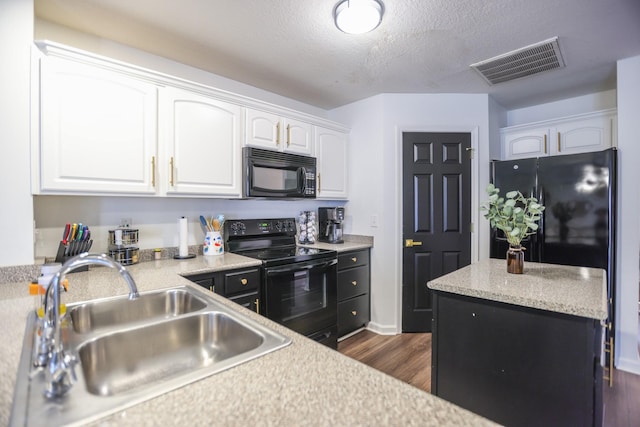 kitchen featuring sink, white cabinets, black appliances, dark wood-type flooring, and a textured ceiling