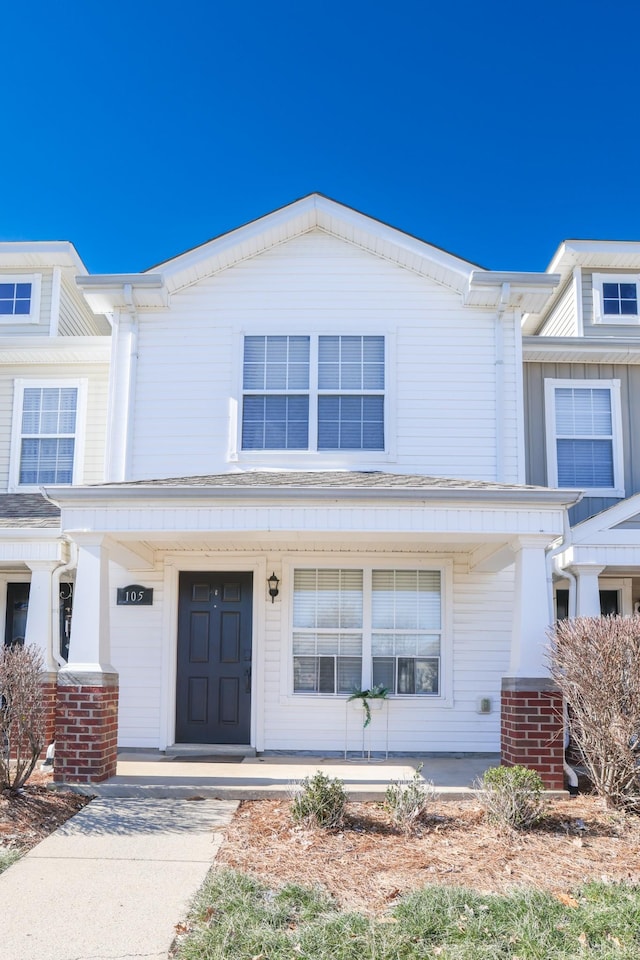 townhome / multi-family property featuring covered porch