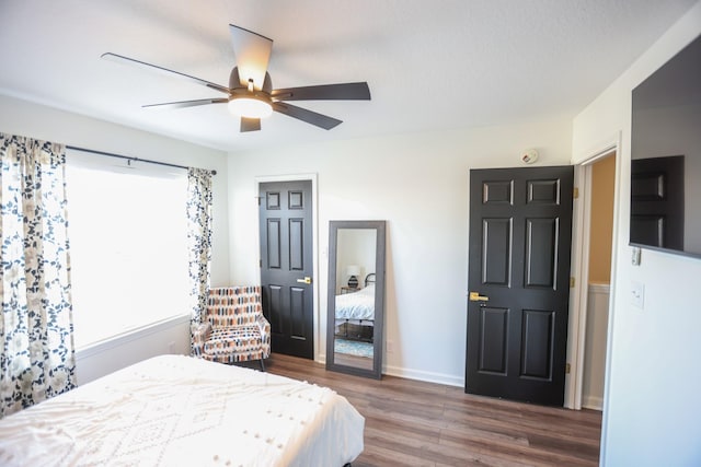 bedroom with dark hardwood / wood-style floors and ceiling fan