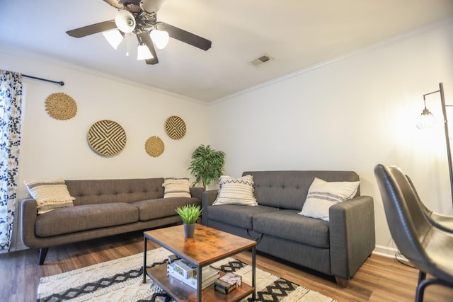 living room with light hardwood / wood-style flooring, ornamental molding, and ceiling fan