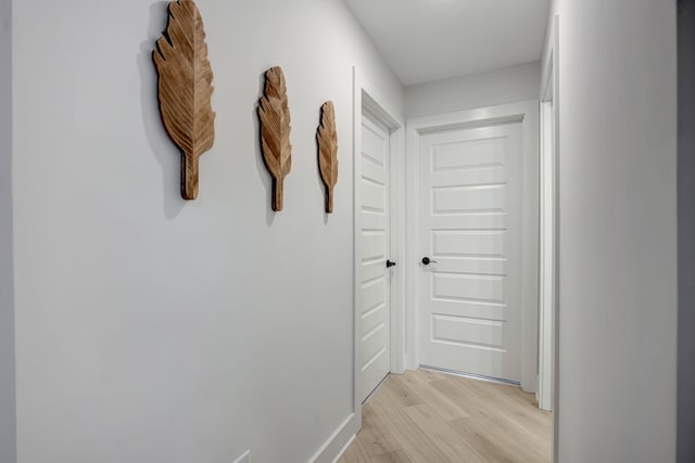 hallway with light hardwood / wood-style floors