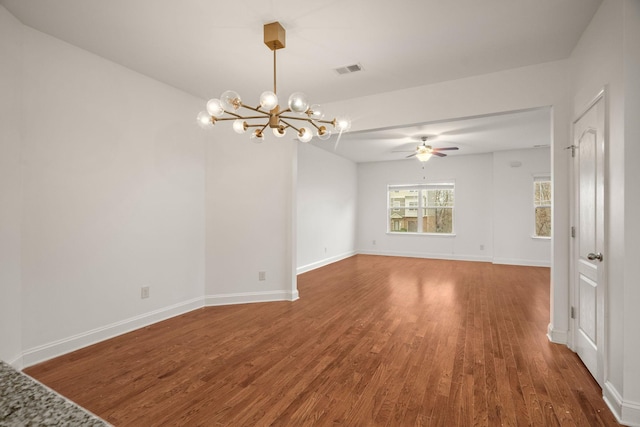 empty room with dark hardwood / wood-style floors and ceiling fan with notable chandelier