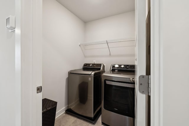 washroom with light tile patterned flooring and washer and dryer