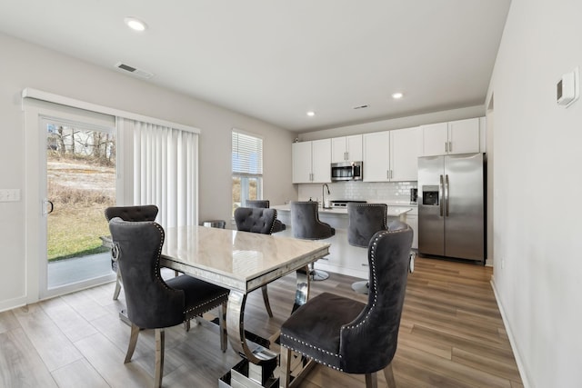 dining area featuring sink and light hardwood / wood-style floors