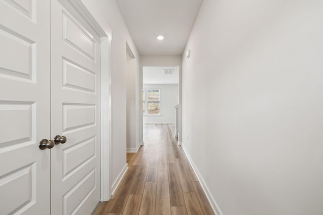 hall with hardwood / wood-style flooring