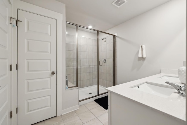 bathroom featuring vanity, tile patterned floors, and a shower with shower door