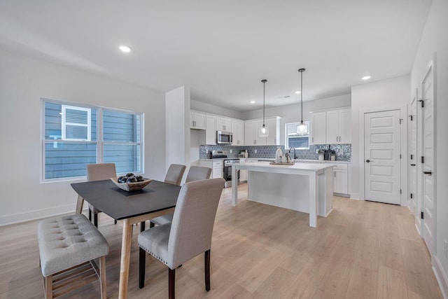 dining space featuring sink and light hardwood / wood-style flooring