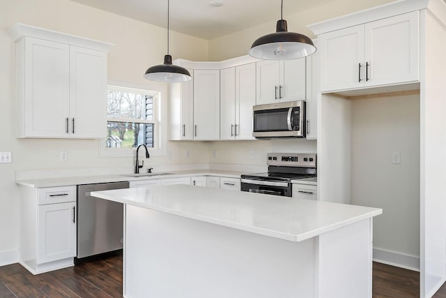 kitchen with sink, appliances with stainless steel finishes, a center island, and pendant lighting