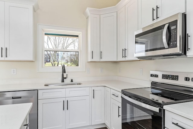 kitchen with sink, stainless steel appliances, and white cabinetry