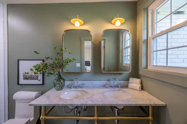 bathroom with sink, toilet, and a healthy amount of sunlight