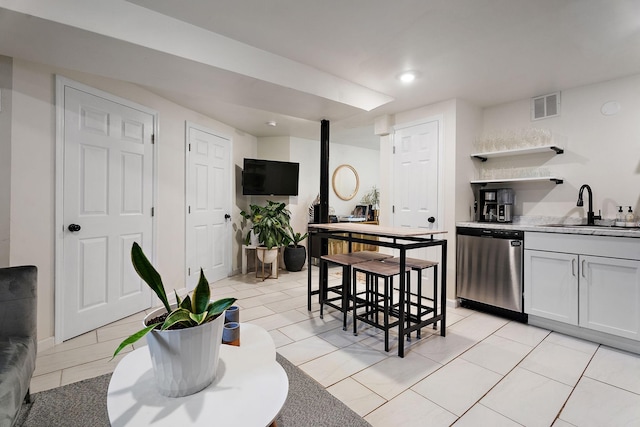 kitchen with white cabinetry, sink, and stainless steel dishwasher