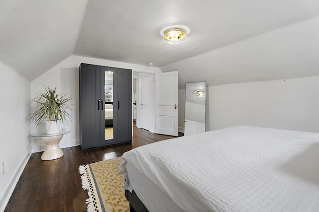 bedroom with lofted ceiling and dark hardwood / wood-style floors