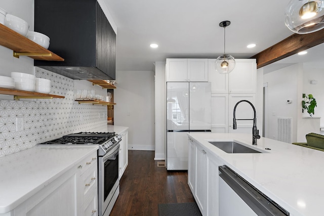 kitchen with stainless steel gas range, sink, white cabinetry, dishwashing machine, and white fridge