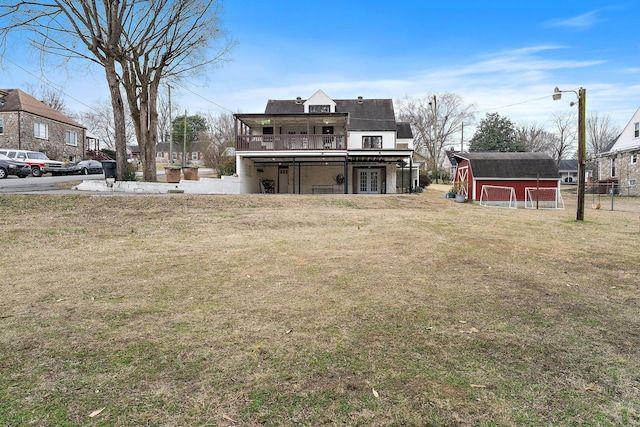 rear view of house featuring a yard and a shed