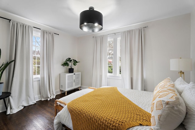 bedroom featuring multiple windows and dark wood-type flooring