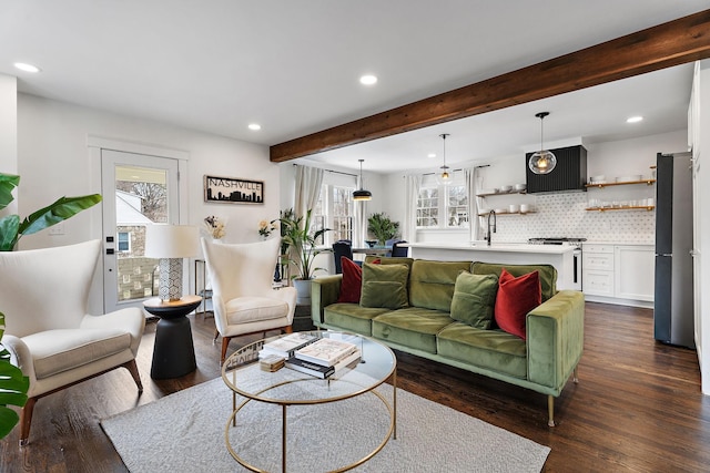 living room featuring sink, beam ceiling, and dark hardwood / wood-style floors