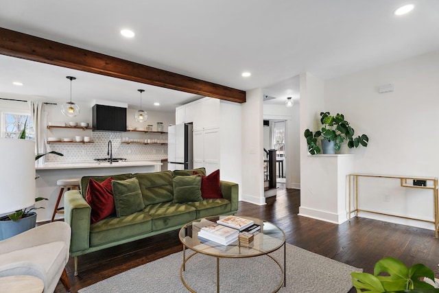 living room featuring beamed ceiling, sink, and dark hardwood / wood-style flooring