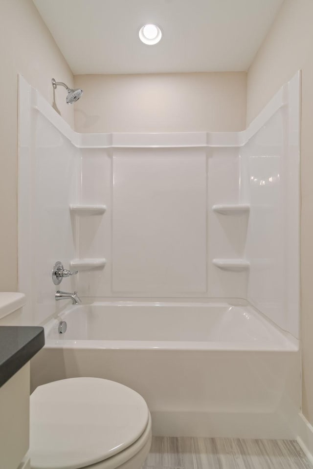 bathroom featuring shower / washtub combination and toilet