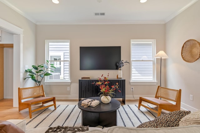 living room with crown molding and light hardwood / wood-style flooring