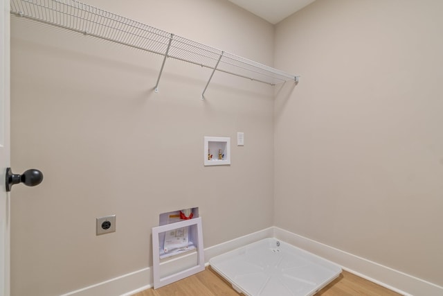 clothes washing area with hardwood / wood-style flooring, washer hookup, and hookup for an electric dryer