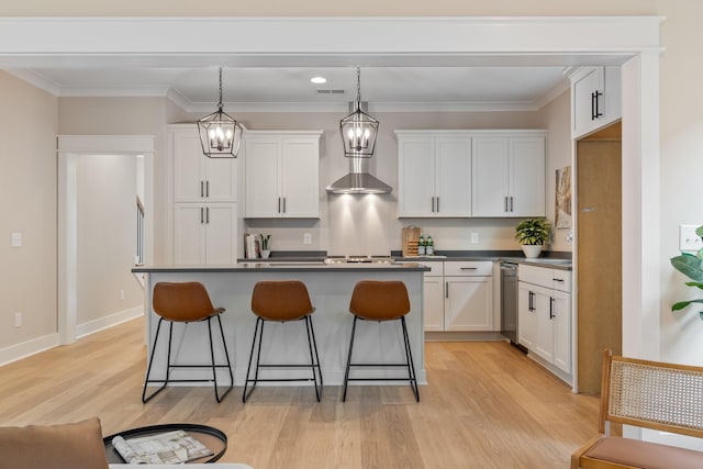 kitchen with pendant lighting, white cabinetry, a kitchen bar, a center island, and light hardwood / wood-style flooring