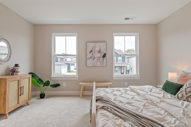 carpeted bedroom featuring multiple windows