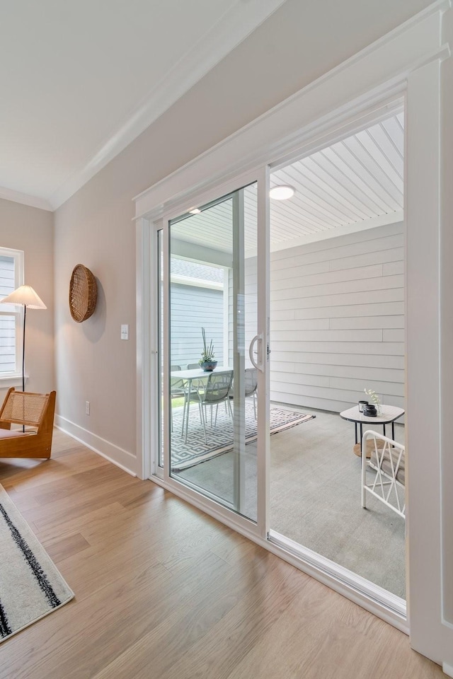 doorway to outside featuring ornamental molding and hardwood / wood-style floors