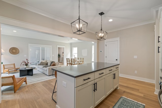 kitchen featuring white cabinetry, a center island, a kitchen bar, decorative light fixtures, and light wood-type flooring