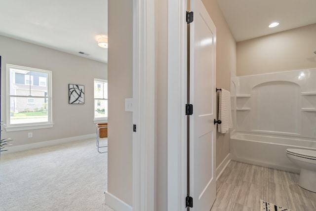 bathroom featuring washtub / shower combination and toilet