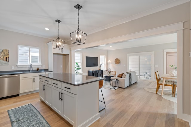 kitchen with a kitchen bar, sink, white cabinetry, hanging light fixtures, and dishwasher