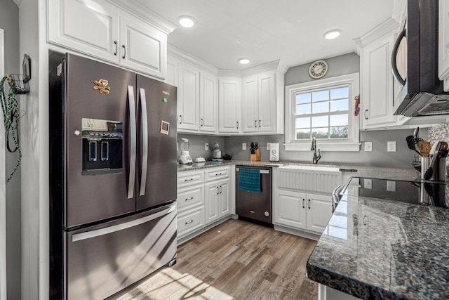 kitchen featuring sink, hardwood / wood-style floors, stainless steel appliances, white cabinets, and dark stone counters